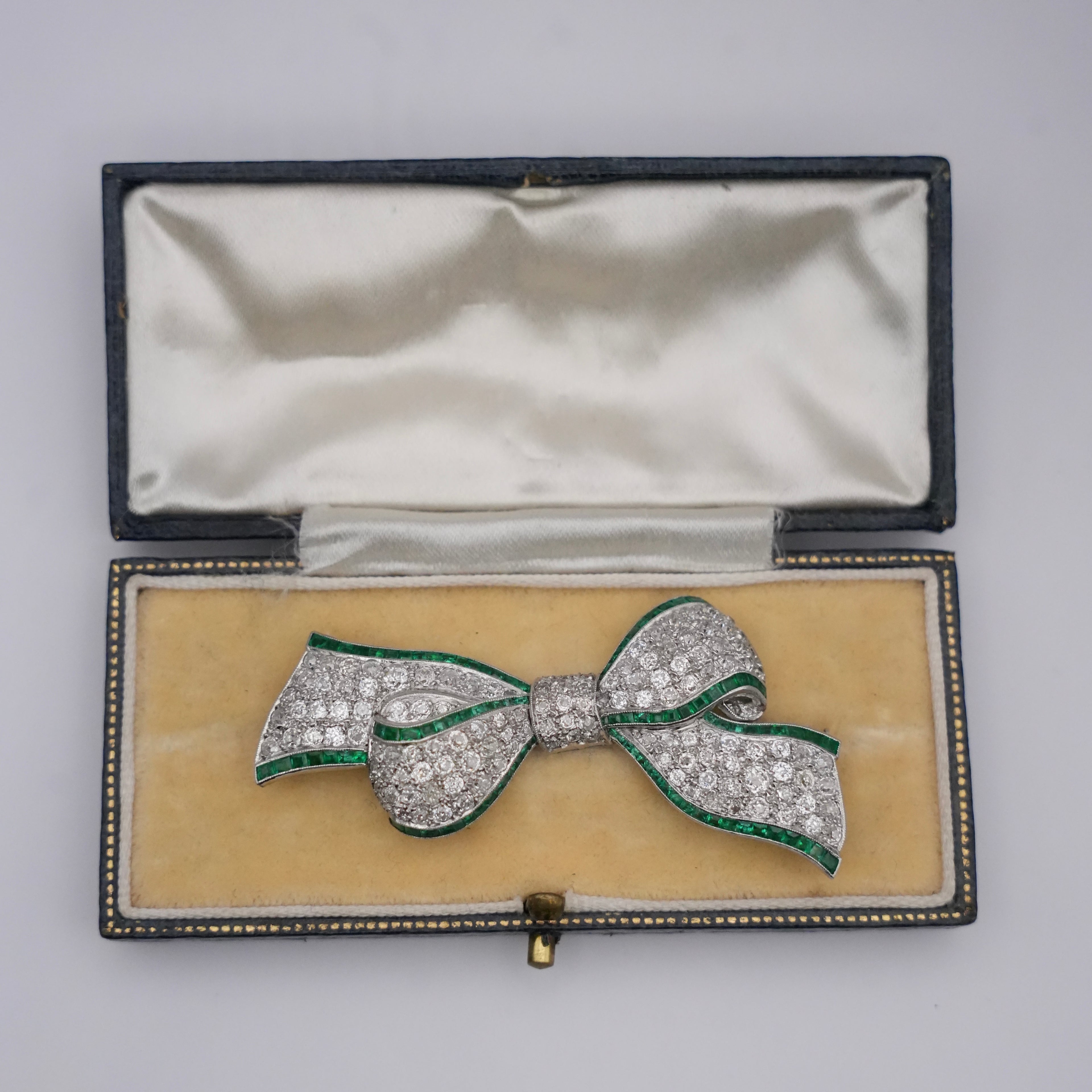 Art Deco Colombian Emerald & Diamond Bow Brooch in Platinum, Circa 1920s