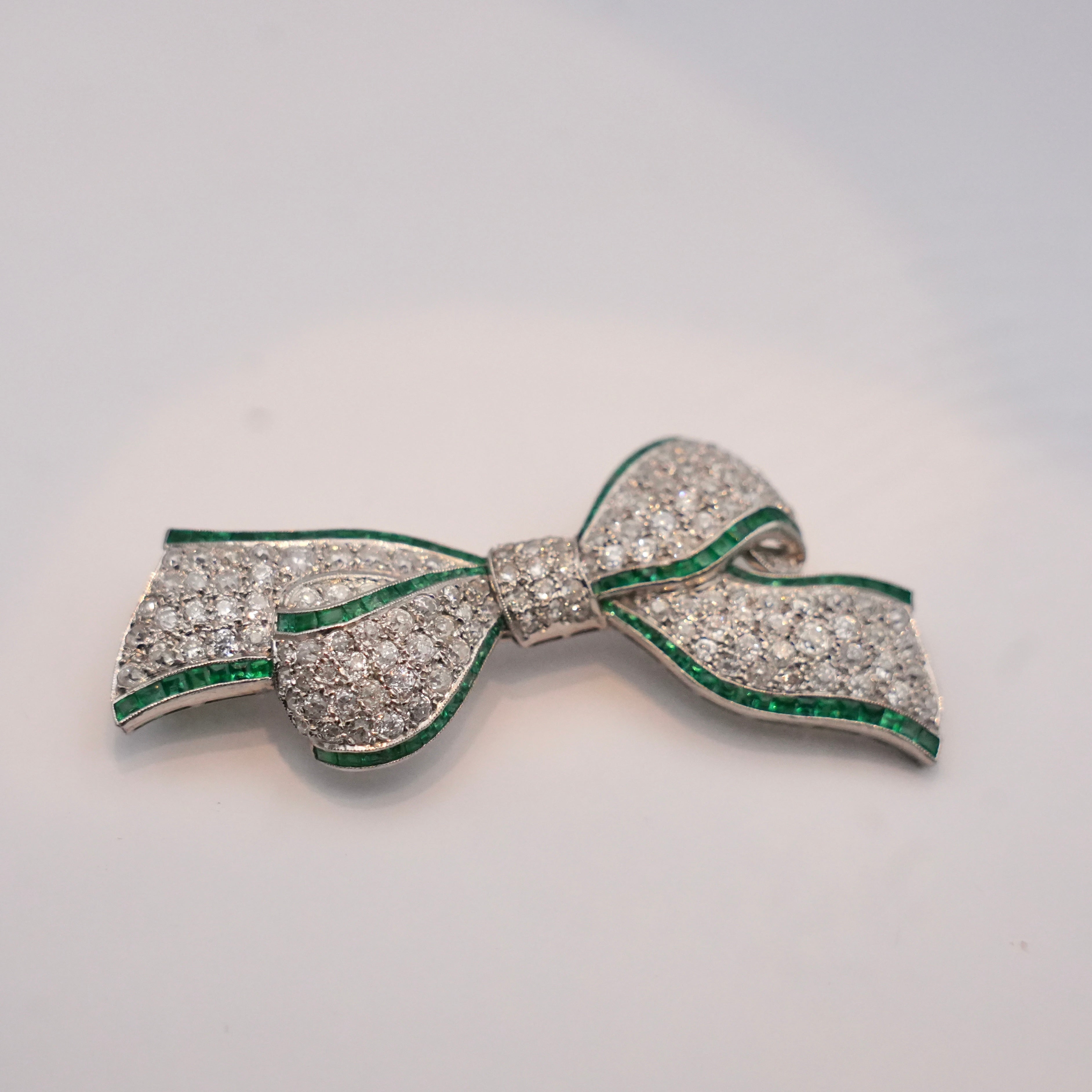 Art Deco Colombian Emerald & Diamond Bow Brooch in Platinum, Circa 1920s